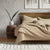 A bed with a tan Delilah Home Organic Cotton Fitted Sheet cover.