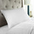 A Cloud Nine Comforts 50/50 White Goose Down & Feather Luxury Pillow | Medium Support on a bed with a headboard.