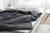 A bed with a black Pillowtex Cotton Duvet Cover for Weighted Blanket and pillows.