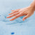 A hand touching a Malouf Isolus 2.5 Inch Gel Memory Foam Topper.