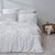 Kassatex's White organic cotton duvet cover on a Kassatex Bamboo floor.