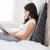 A woman reading a book on a bed with a hypoallergenic Z Wedge Pillow by Malouf.