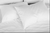 A monochromatic image of a neatly made bed with crisp white sheets and hypoallergenic, Westin® Heavenly Firm Support Polyester Bed Pillows by Hollander inviting a peaceful and comfortable rest.